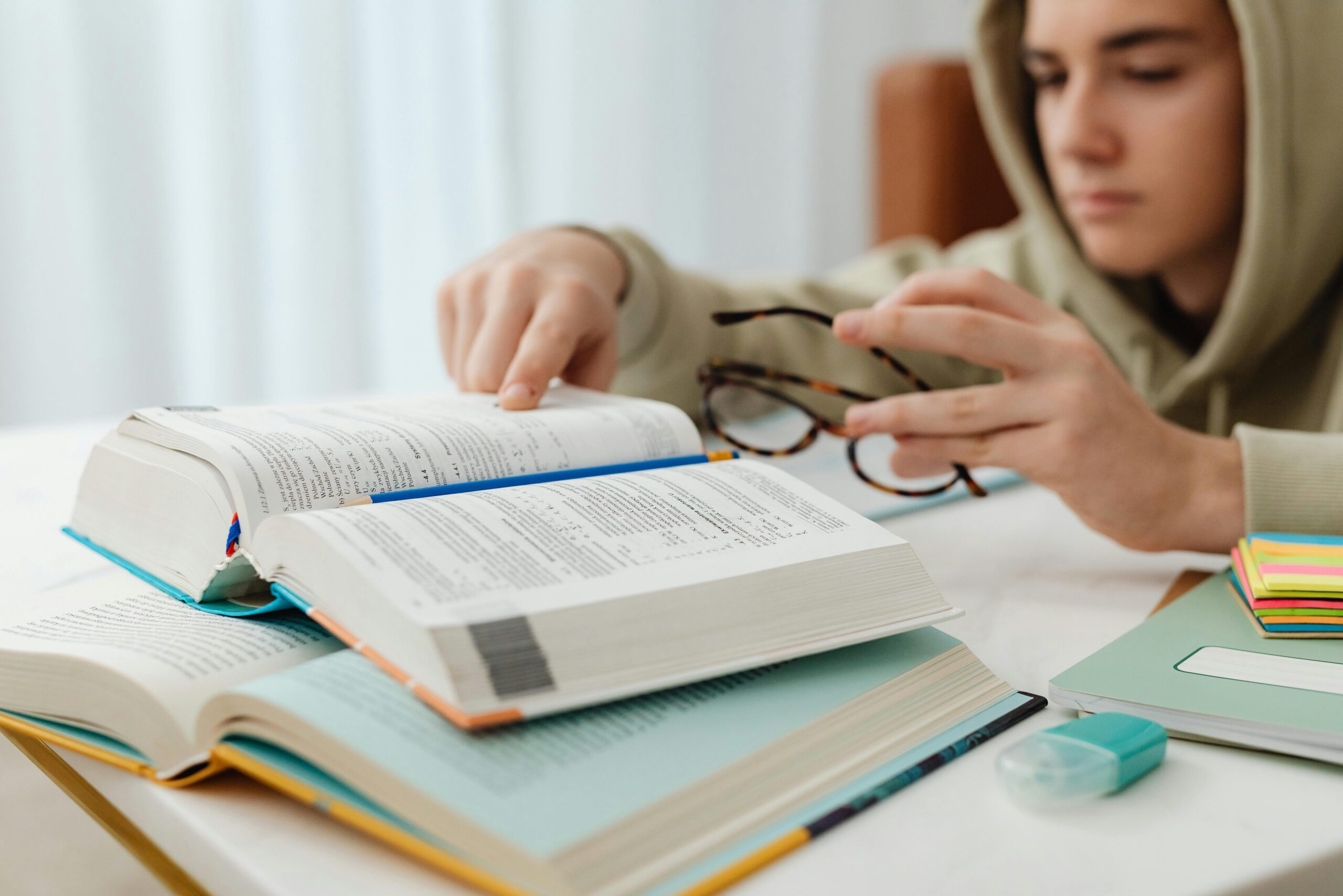 Persona señalando libro con gafas en la mano – consejos para aprovechar test de oposiciones